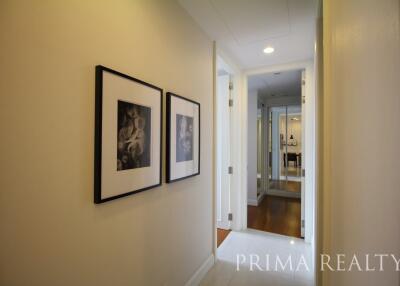 Bright hallway with framed pictures leading to rooms