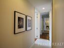 Bright hallway with framed pictures leading to rooms