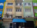 Exterior of a multi-story urban building with balconies and storefronts