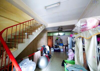 Cluttered area under a staircase with storage and exercise equipment
