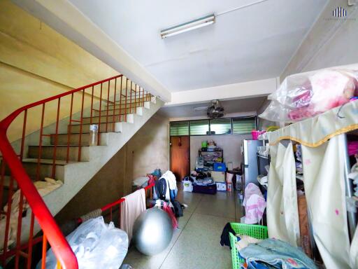 Cluttered area under a staircase with storage and exercise equipment