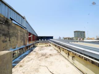 Rooftop area of a building with some structures and city view in the distance