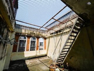 Outdoor courtyard with a netted rooftop and stairs