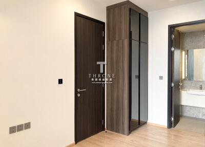 Modern bedroom entryway with sleek wardrobe and welcoming wooden door