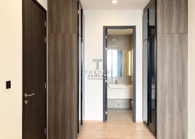 Modern hallway interior with wood finish and entry to a bathroom