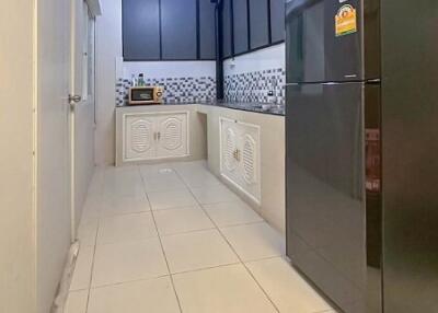 Compact kitchen area with modern appliances and tiled flooring
