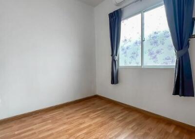 Bright and empty bedroom with wooden floor and a window