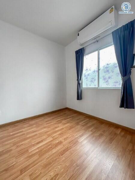 Bright and empty bedroom with wooden floor and a window