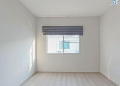 Bright empty bedroom with large window and blinds