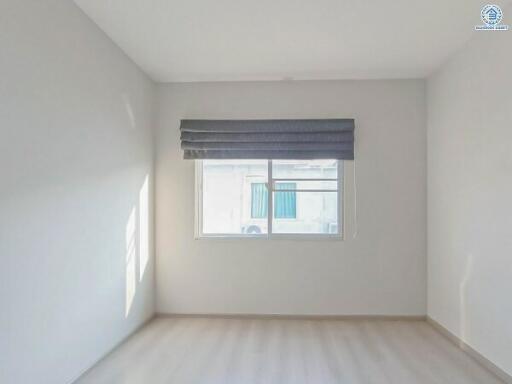 Bright empty bedroom with large window and blinds