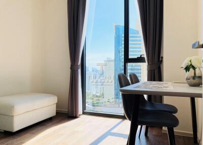 Bright living room with large window view, modern furniture, and city skyline