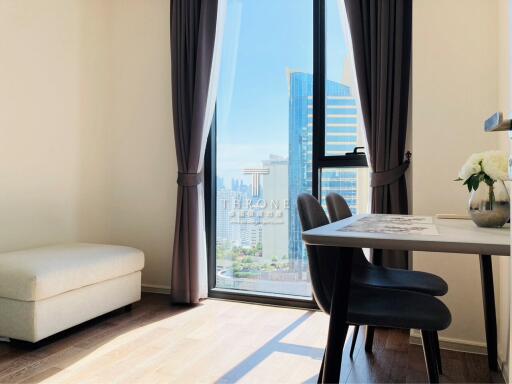 Bright living room with large window view, modern furniture, and city skyline