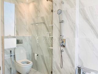 Modern marble tiled bathroom with walk-in shower and toilet