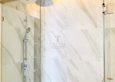 Elegant bathroom with marble walls and glass shower enclosure