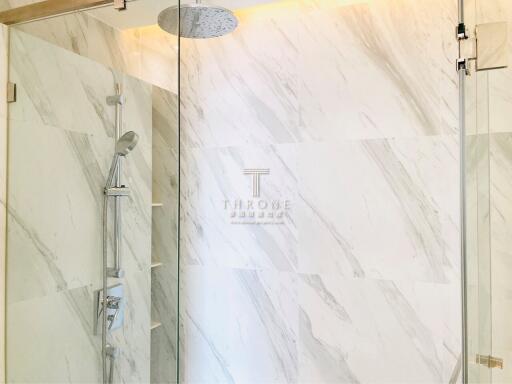 Elegant bathroom with marble walls and glass shower enclosure