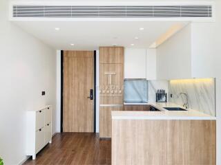 Modern kitchen with wooden finishes and marble countertops in a bright apartment