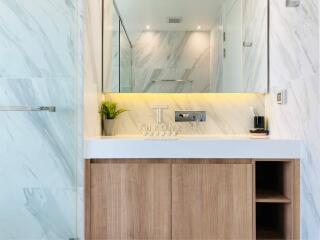 Modern bathroom with marble walls and wooden vanity