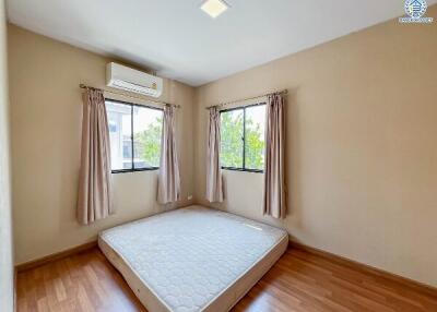 Airy bedroom with natural light, hardwood floors, and air conditioning unit