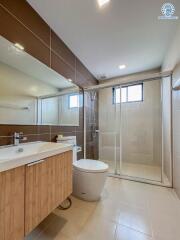 Modern bathroom with glass shower cubicle and wooden vanity