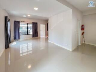 Spacious and bright empty living room with large windows and glossy tiled floor