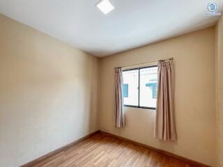 Bright and clean bedroom with a window and hardwood floors