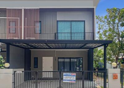 Modern two-story house with balcony and secure fencing