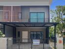 Modern two-story house with balcony and secure fencing