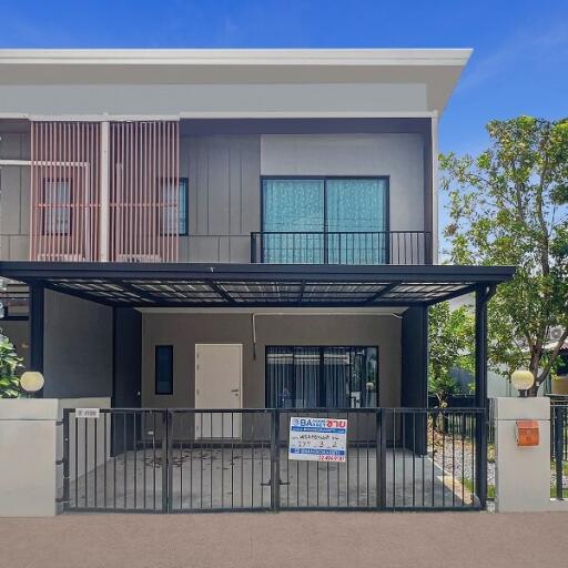 Modern two-story house with balcony and secure fencing