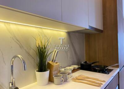 Modern kitchen with marble backsplash and under-cabinet lighting