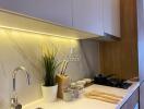 Modern kitchen with marble backsplash and under-cabinet lighting