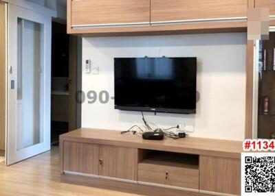 Modern living room interior with mounted television and wooden furniture