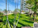 Apartment building with green lawn and palm trees in the foreground