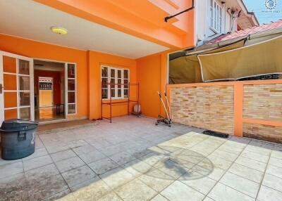 Spacious and well-lit front patio of a residential building with tiled flooring and orange walls