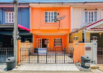 Bright orange two-story residential building with balcony and gated entrance