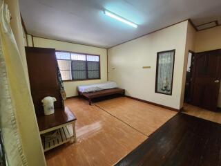 Spacious bedroom with wooden flooring and large windows