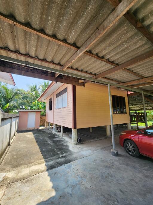 Exterior view of a raised house with underneath car parking