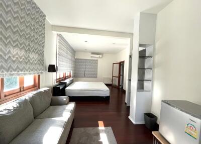 Spacious and well-lit bedroom with a comfortable sitting area and modern decor