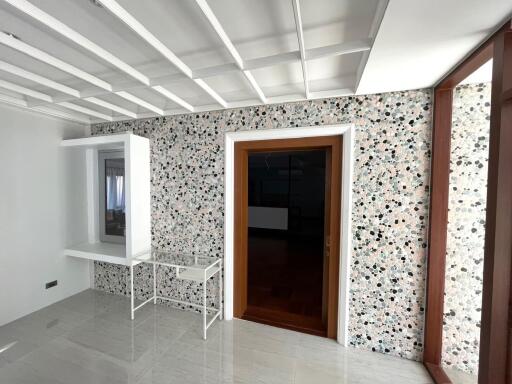 Spacious living room with terrazzo flooring and white ceiling beams