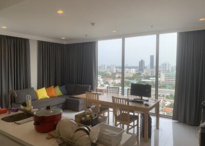 Spacious living room with large windows, dining table, and city view