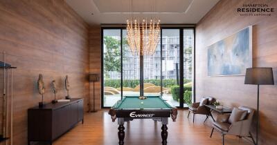 Elegant living room with billiard table, modern furniture, and striking chandelier