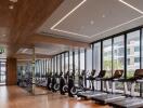 Modern gym facility in residential building with large windows and wooden accents