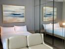 Modern bedroom with white double bed, beige sofa, and mirrored wardrobe