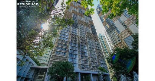 Exterior view of Hampton Residence skyscraper with lush greenery