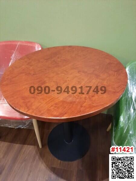 Wooden round table with contact number in a room with green walls