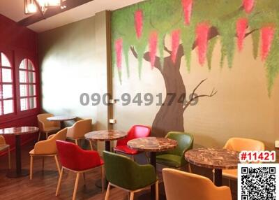Cozy cafe interior with colorful chairs and artistic wall mural