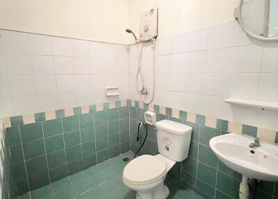 Compact bathroom with white and green tile decor