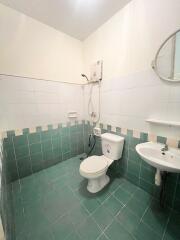 Compact bathroom with white and green tile decor