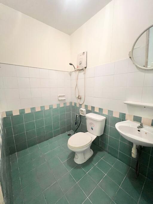 Compact bathroom with white and green tile decor