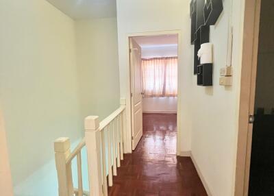 Brightly lit hallway with wooden floors and white walls