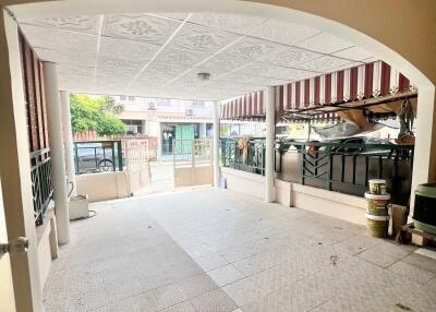 Spacious front patio with tiled flooring and covered parking area